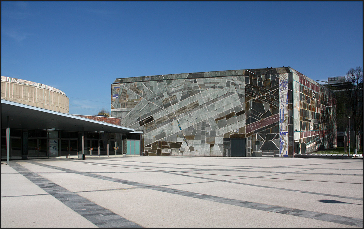 
. Die Liederhalle in Stuttgart -

Blick zum fünfeckigen Mozartsaal. Die Fassade besteht aus einem Mosaik aus Quarzitplättchen in unterschiedlicher Größe und Farbe.

April 2015 (M)