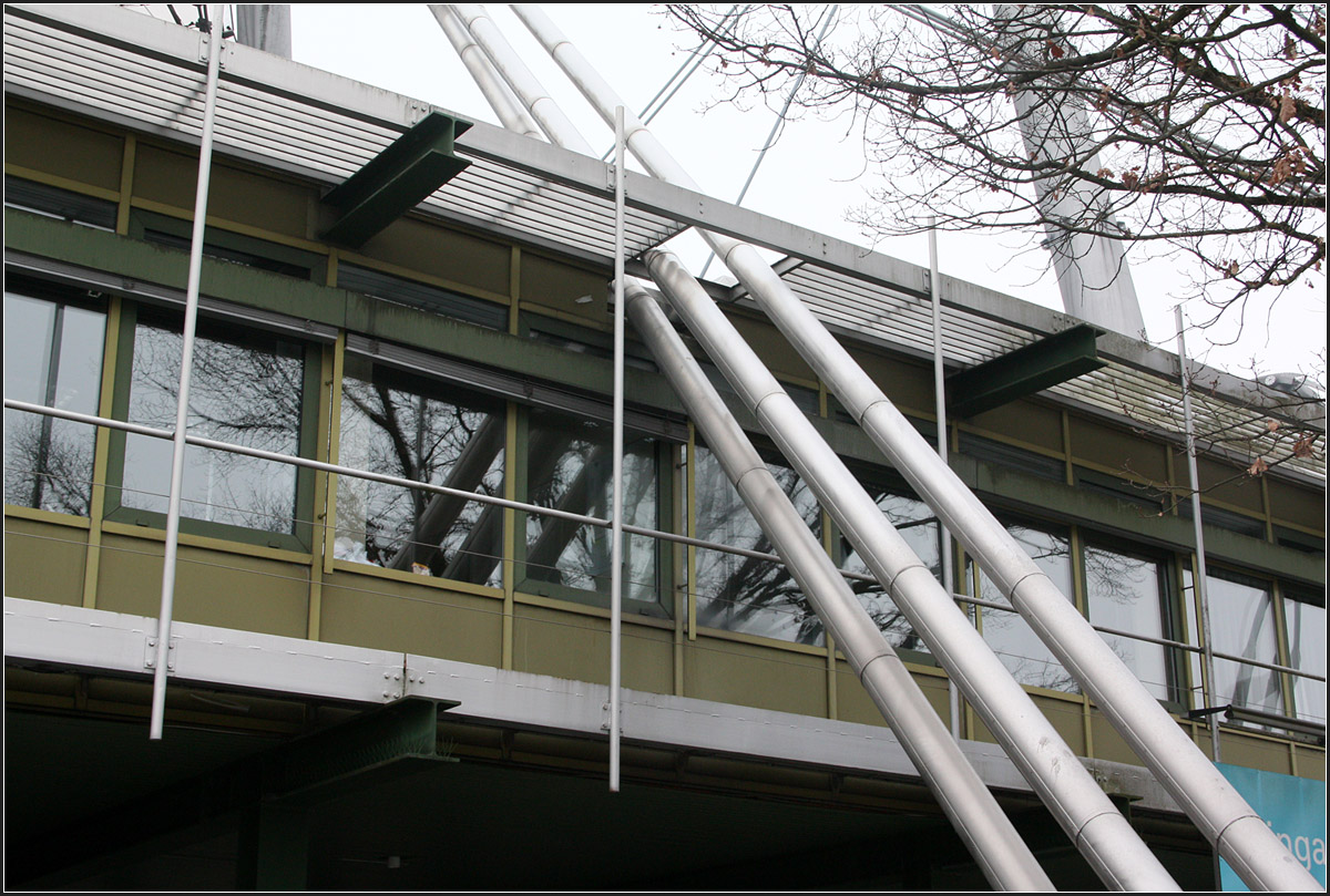 . Verwaltungsgebäude im Olympiapark in München -

Die Stahlseile der Olympiahalle durchstoßen das Gebäude.

März 2015 (Matthias)