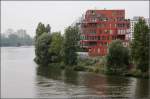 . Wohnen am Wasser in Frankfurt am Main -

Blick von der Friedensbrücke auf das östliche der beiden Wohnhäuser mit der roten Fassade.

September 2014 (Matthias)