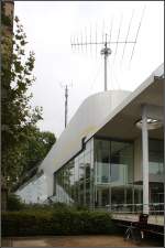 . Das Museum für Post und Kommunikation in Frankfurt am Main -

Ein Großteil des Museum befindet sich im Garten im Untergeschoss. Eine alle Geschosse verbindende Halle befindet sich unter der großen schräg gestellten Glastonne. Ein schöne Detail ist auch wie das Vordach unter der Aluminumverkleidung hervor tritt.

September 1990 (Matthias)
