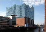
. Die Elbphilharmonie in Hamburg -

Blick vom Sandtorhafen auf die Ost- und Nordfassaden der Elbphilharmonie. Die Grundform des Speichers, der nach Osten breiter wird, nimmt der aufgesetzte Teil auf.

Oktober 2015 (M)